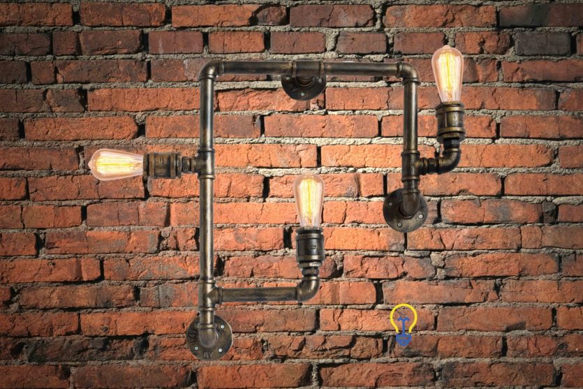 Industriële lamp gemaakt van waterleidingen. Een stoere steampunk wandlamp voor industriële interieurs in barren, winkels en restaurants en oude fabriekshallen.